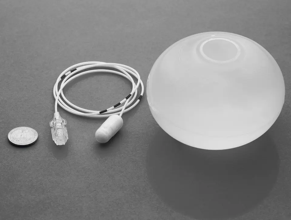 The Allurion gastric balloon: a coin on the left for size comparison, next to it the capsule with the thin filling tube, the filled balloon on the right
