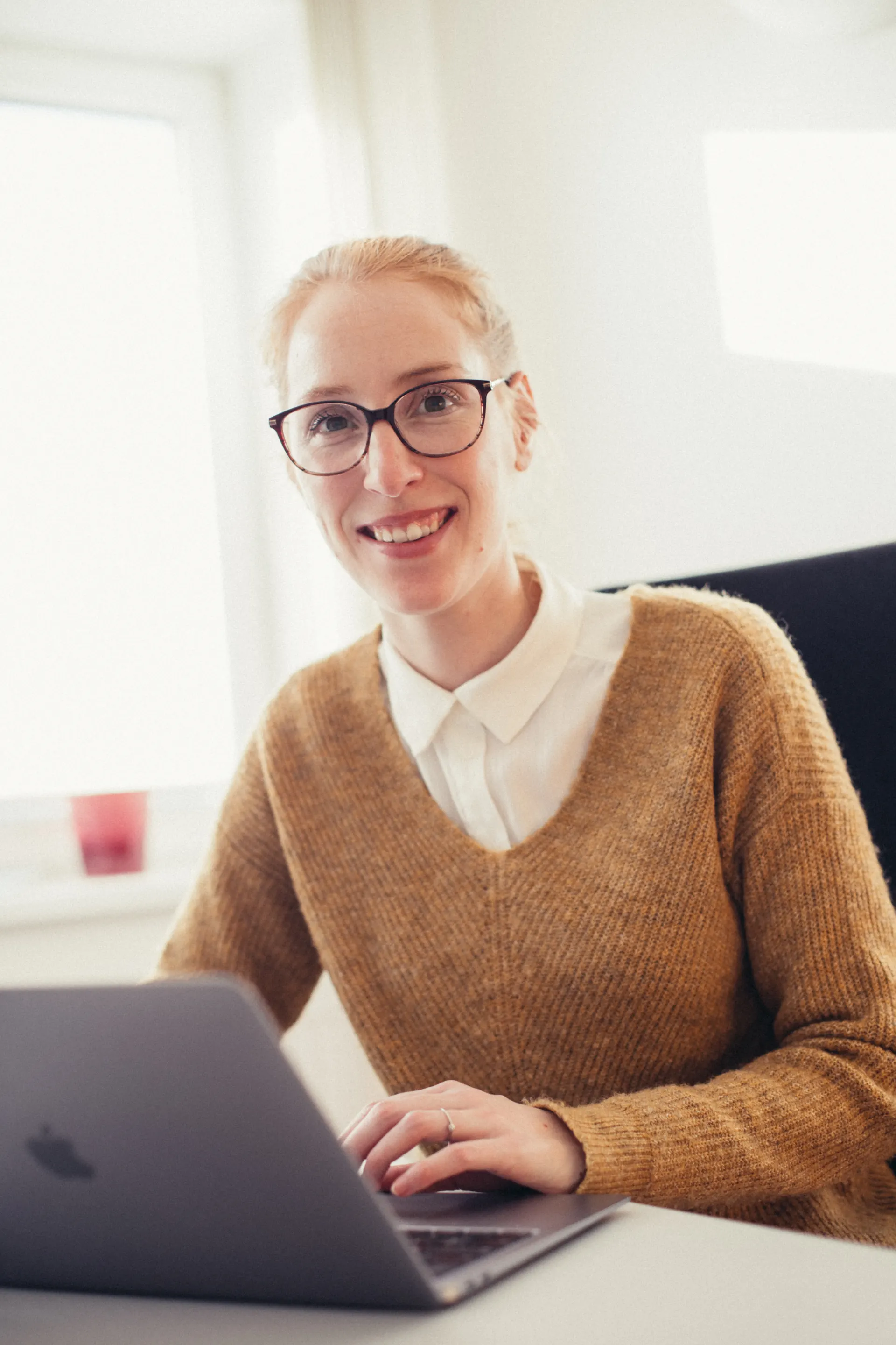 Adviseur van Weight Doctors® by die lessenaar met ’n skootrekenaar