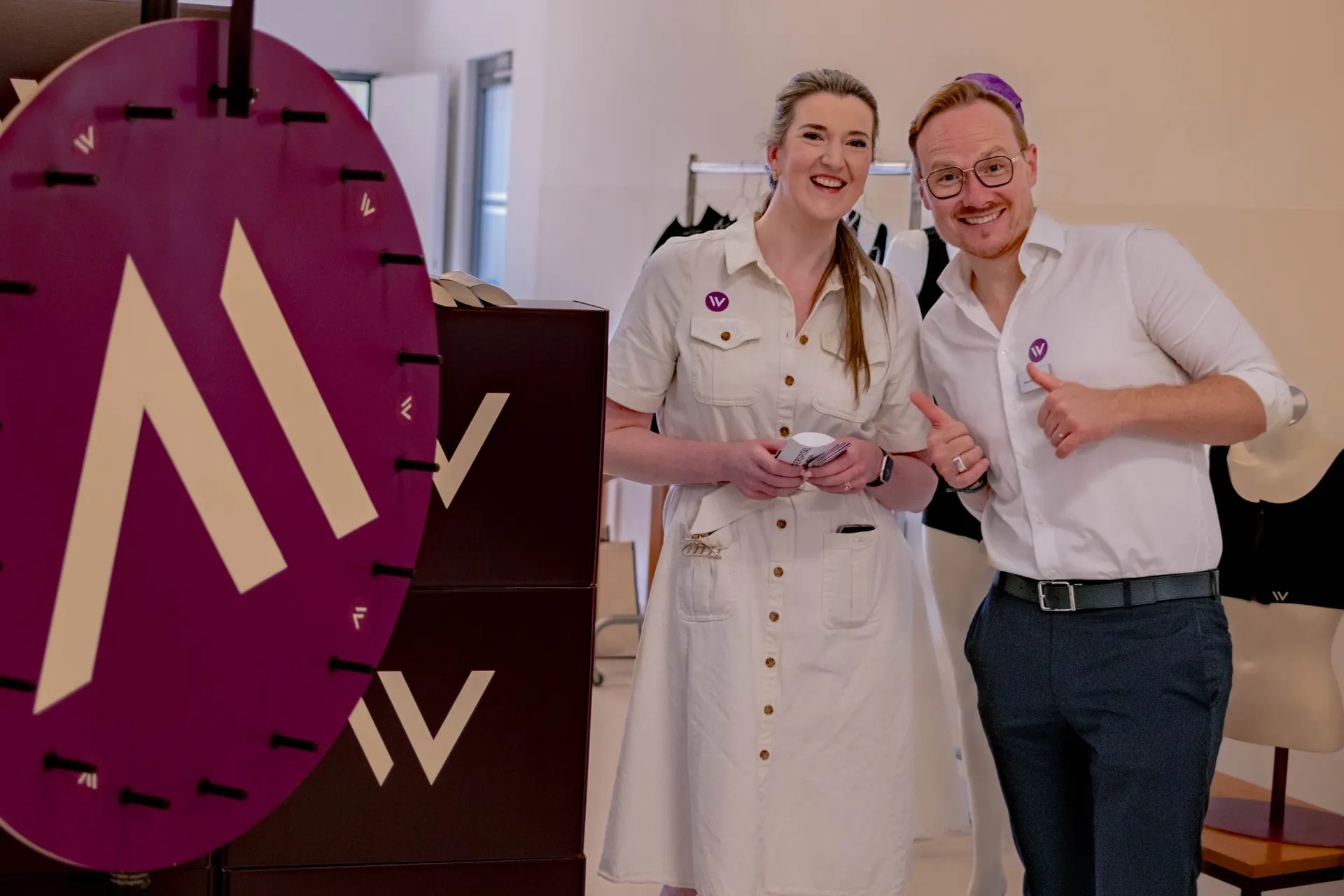 Two Weight Doctors® team members laughing next to the purple W wheel of fortune